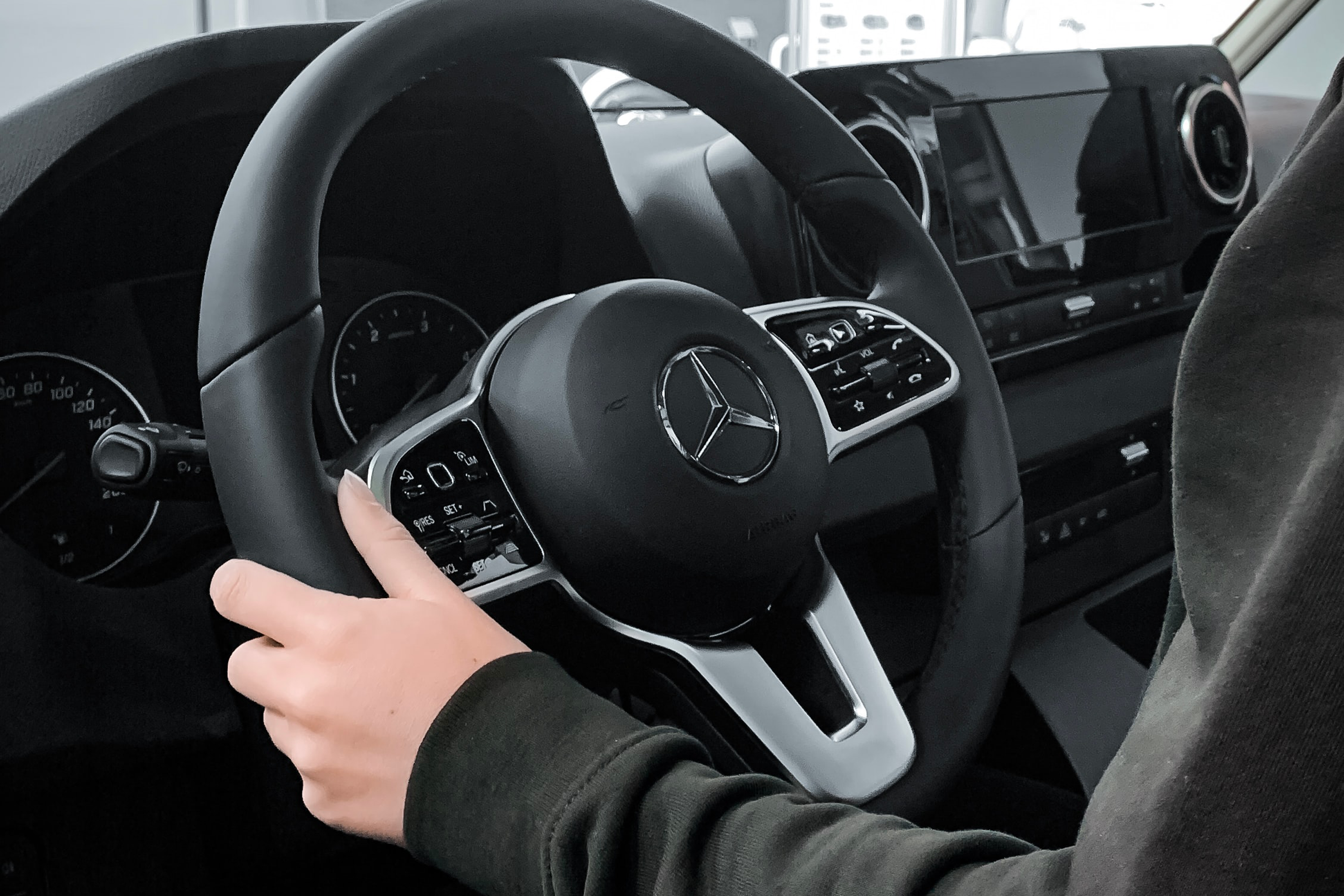 steering wheel of sprinter van hand holding the steering wheel of a mercedes sprinter van