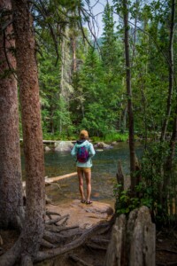 woman standing in front of water, hiking