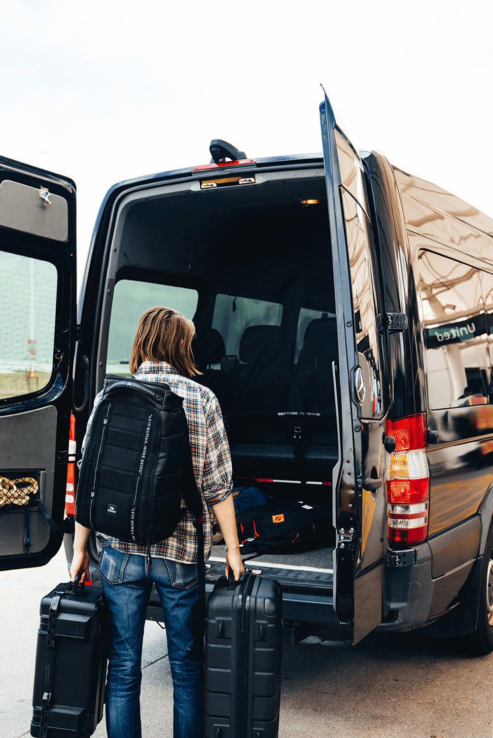 Passenger loading a sprinter van with luggage