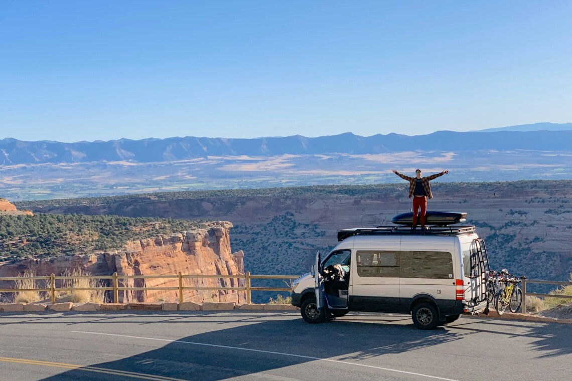 man standing on van outside of Colorado National Monument