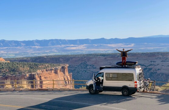 man standing on van outside of Colorado National Monument